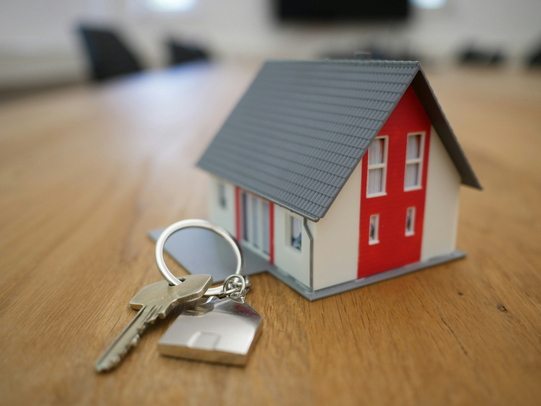 A toy house with a key signifying a real estate purchase