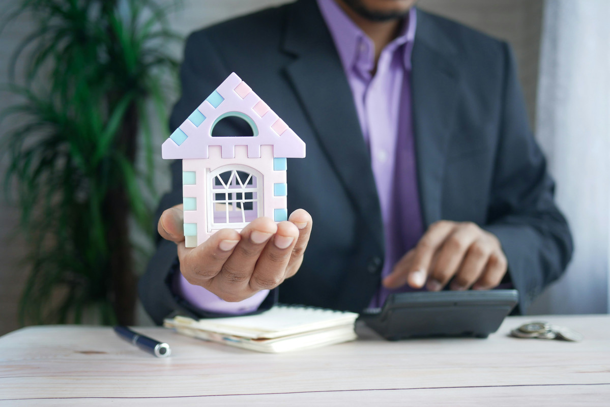Mortgage provider holding a toy house
