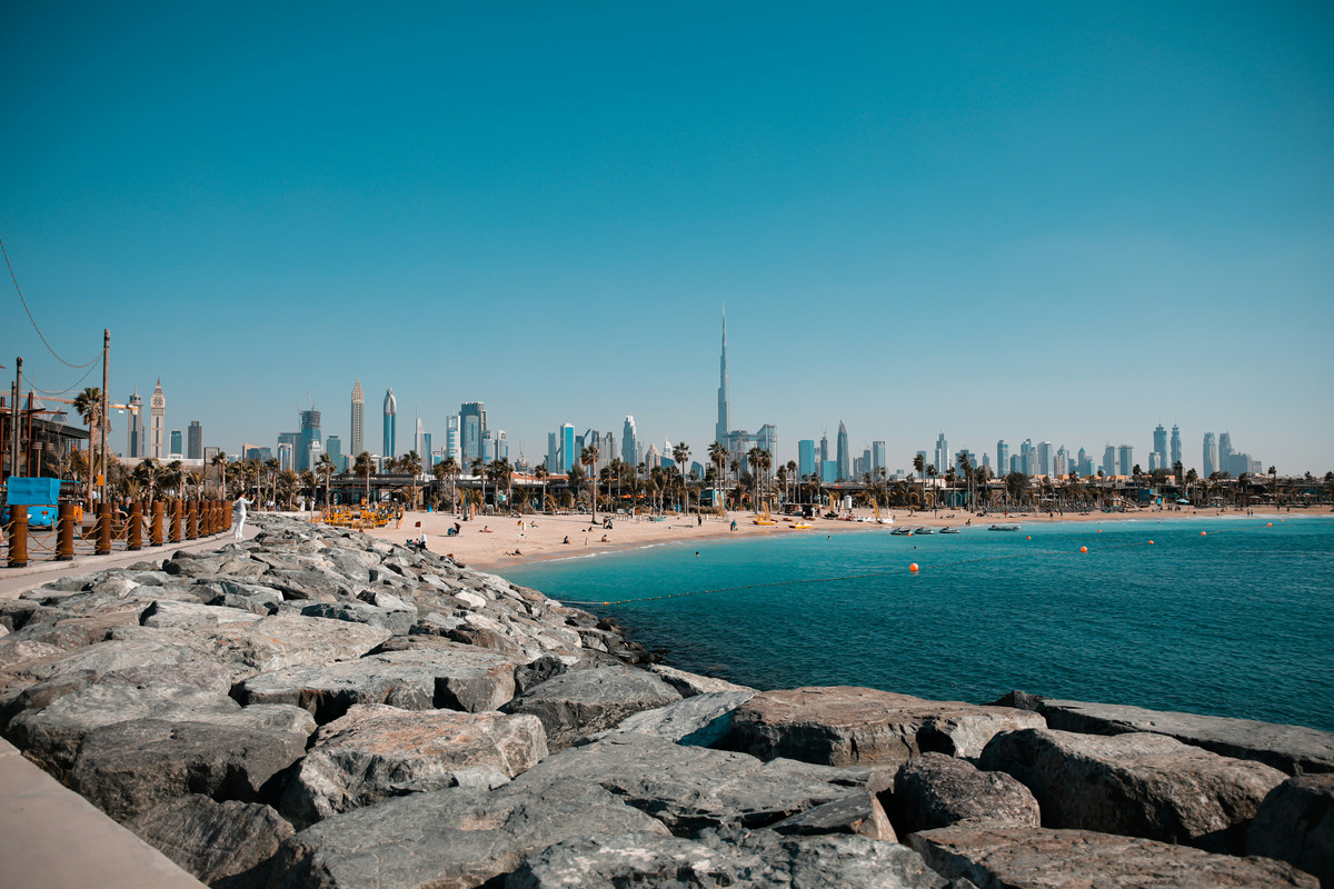 Image of the Dubai beach with the skyline of Dubai behind it.